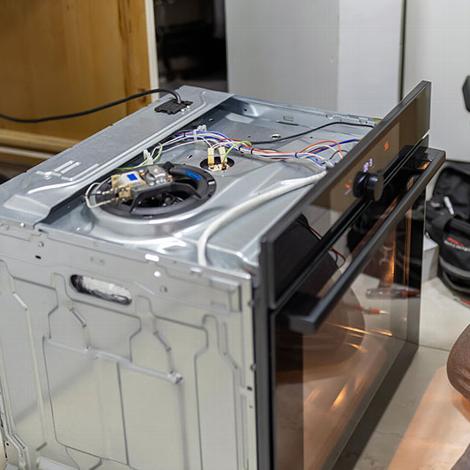Electric oven interior with visible wiring and components.